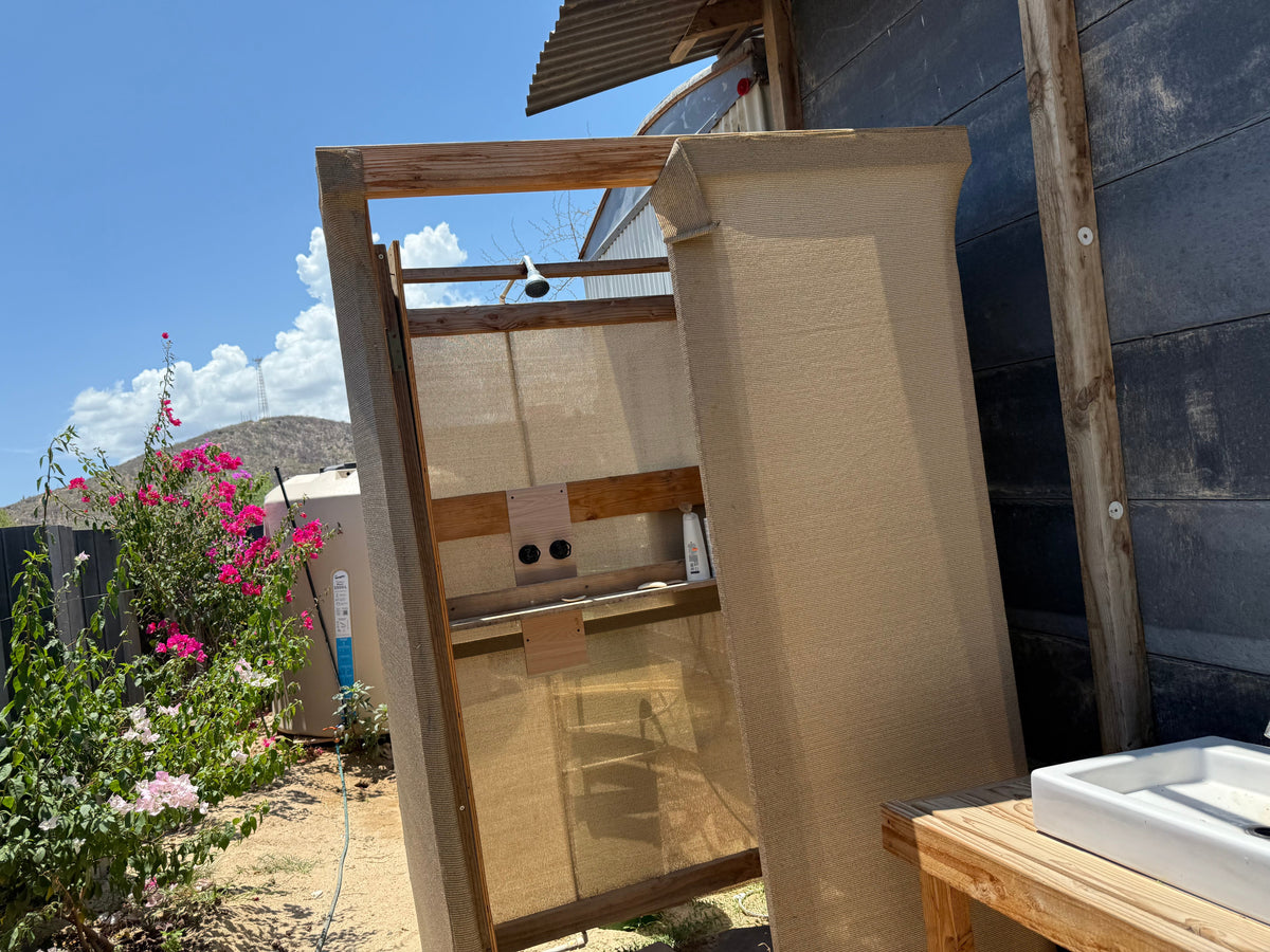 Regadera con malla sombra. Referencia del material, no baño completo ni cerramiento impermeable.